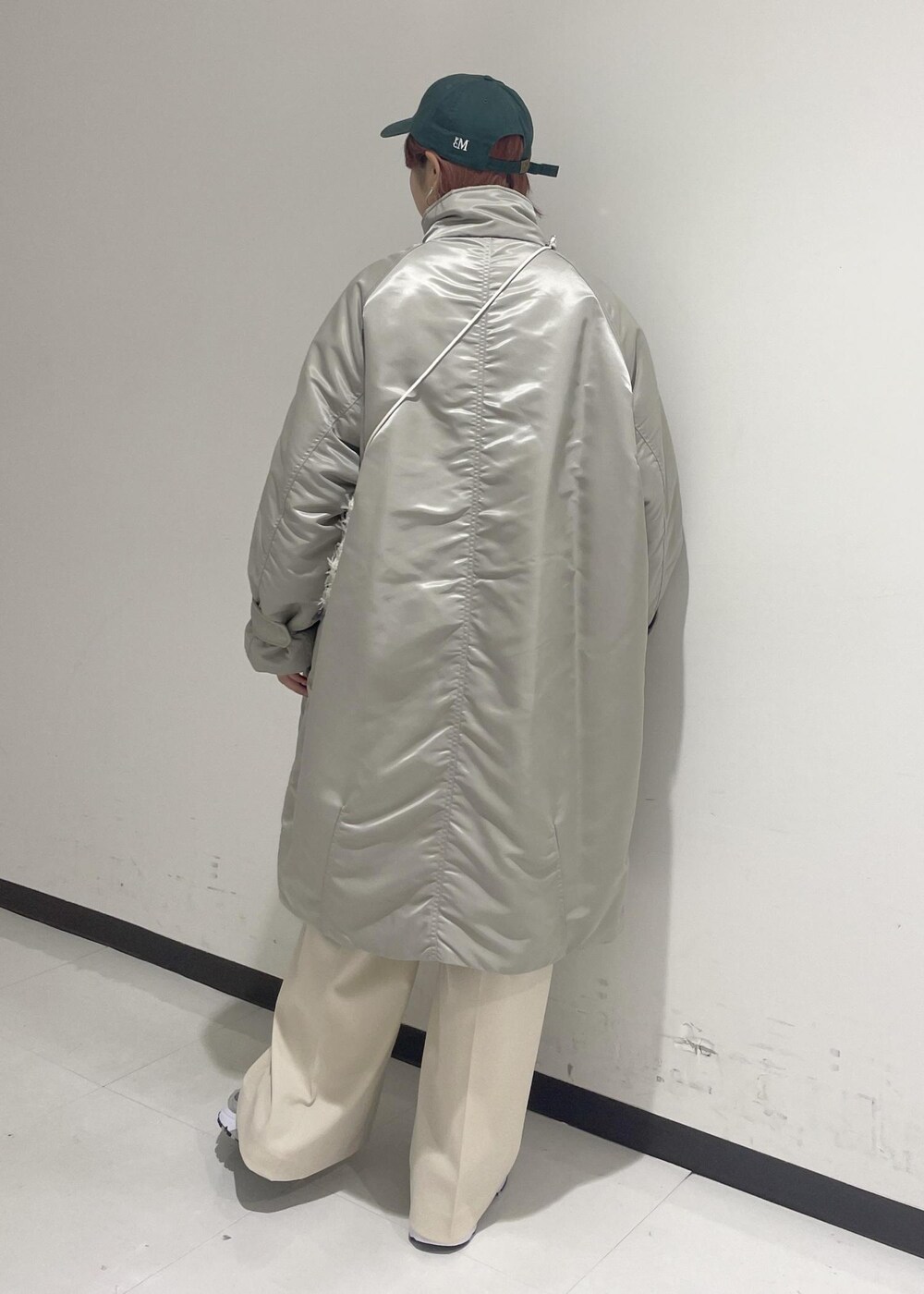 ホワイト系のスラックス、グリーン系のスウェット、ホワイト系のショルダーバッグを着用したレディースの秋コーディネートの3枚目の写真