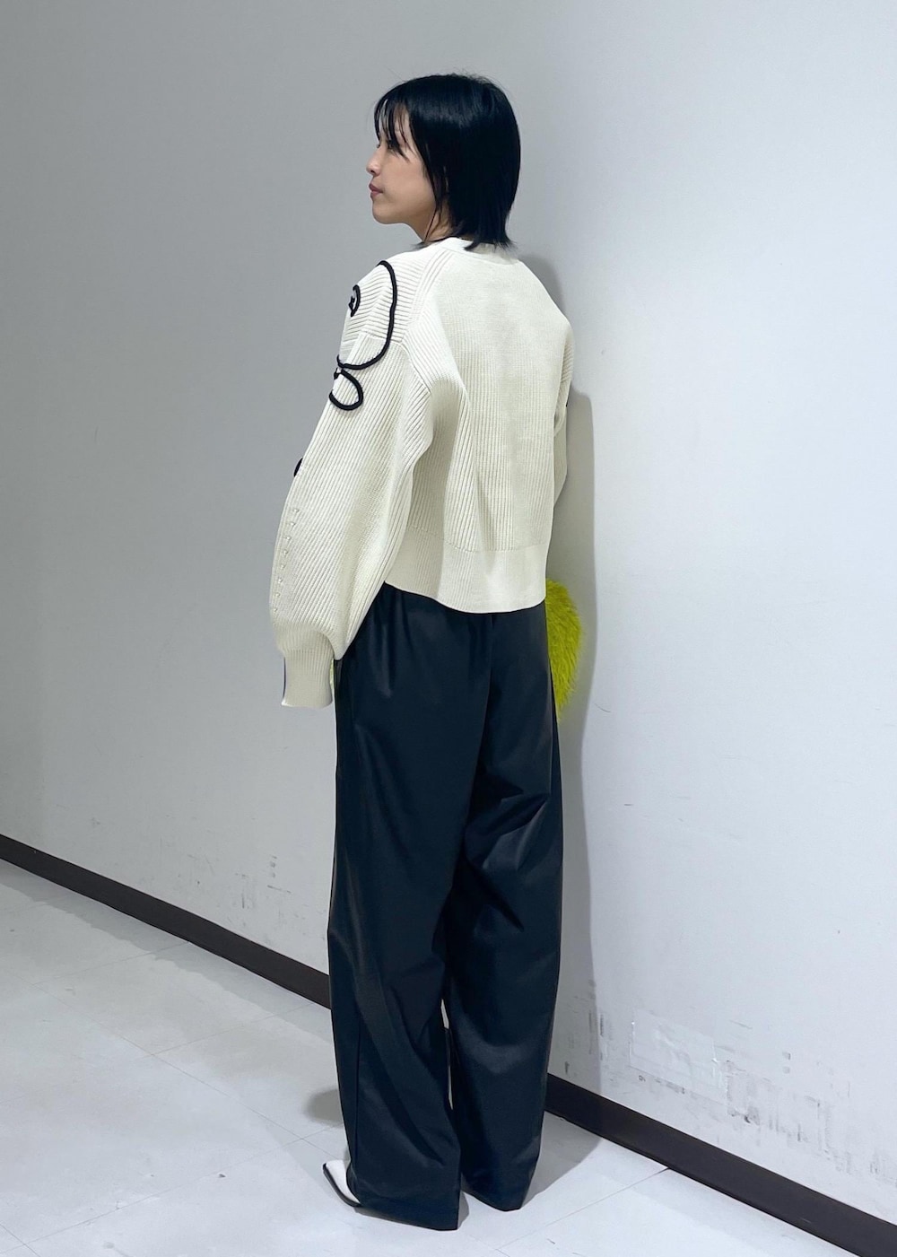 ホワイト系のパンプス、ホワイト系のカーディガン/ボレロ、グリーン系のハンドバッグを着用したレディースの秋コーディネートの3枚目の写真