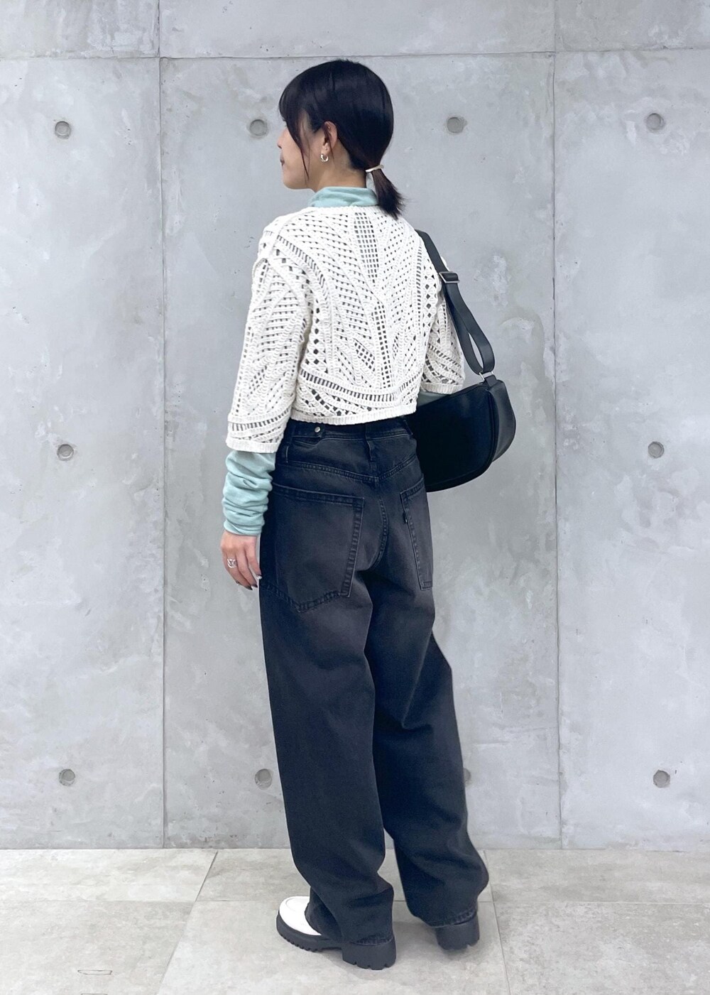 ホワイト系のローファー、グリーン系のニット/セーター、ブラック系のデニムパンツを着用したレディースの冬コーディネートの3枚目の写真