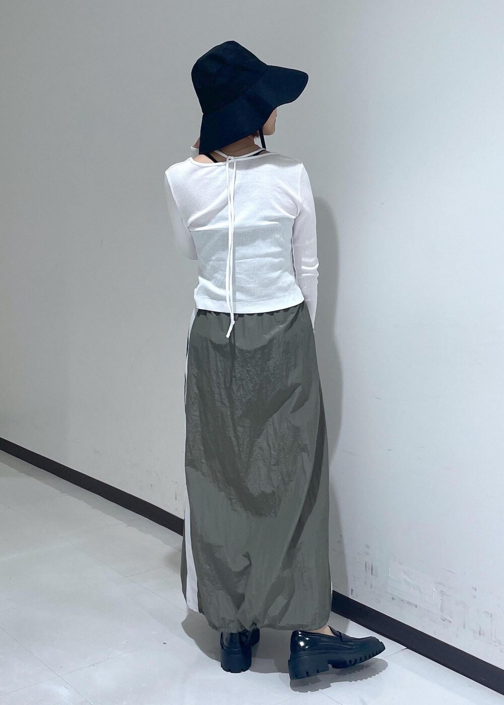 ブラック系のローファー、グリーン系のスカート、ホワイト系のカーディガン/ボレロを着用したレディースの春コーディネートの3枚目の写真