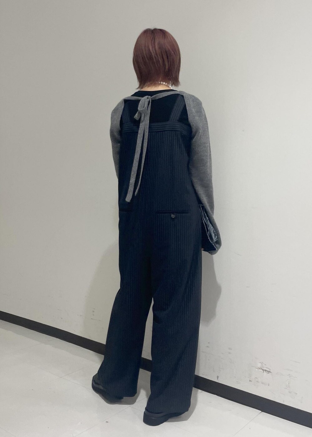 ブラック系のブーツ、ブラック系のTシャツ/カットソー、グレー系の手袋を着用したレディースの秋コーディネートの3枚目の写真