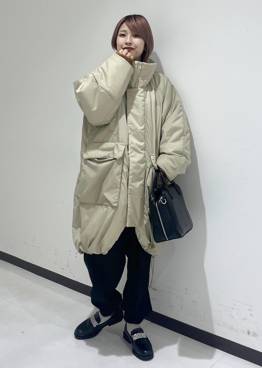 ブラック系のボストンバッグ、ベージュ系のその他アウター、ブラック系のローファーを着用したレディースの冬コーディネートの5枚目の写真