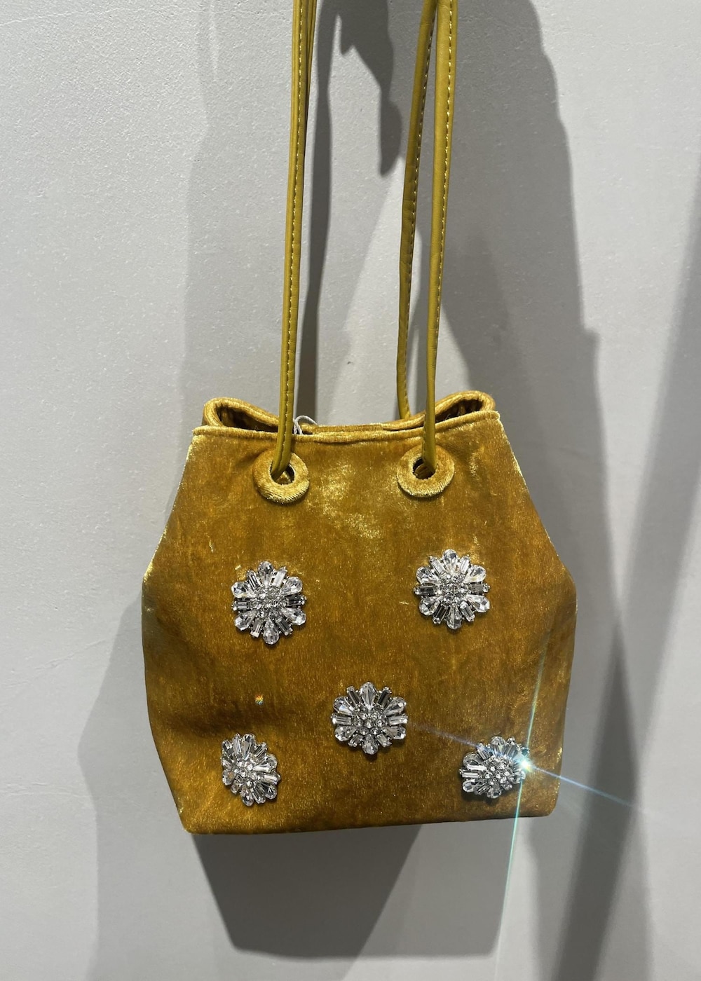 ブラック系のブーツ、グリーン系のニット/セーター、イエロー系のハンドバッグを着用したレディースの秋コーディネートの5枚目の写真