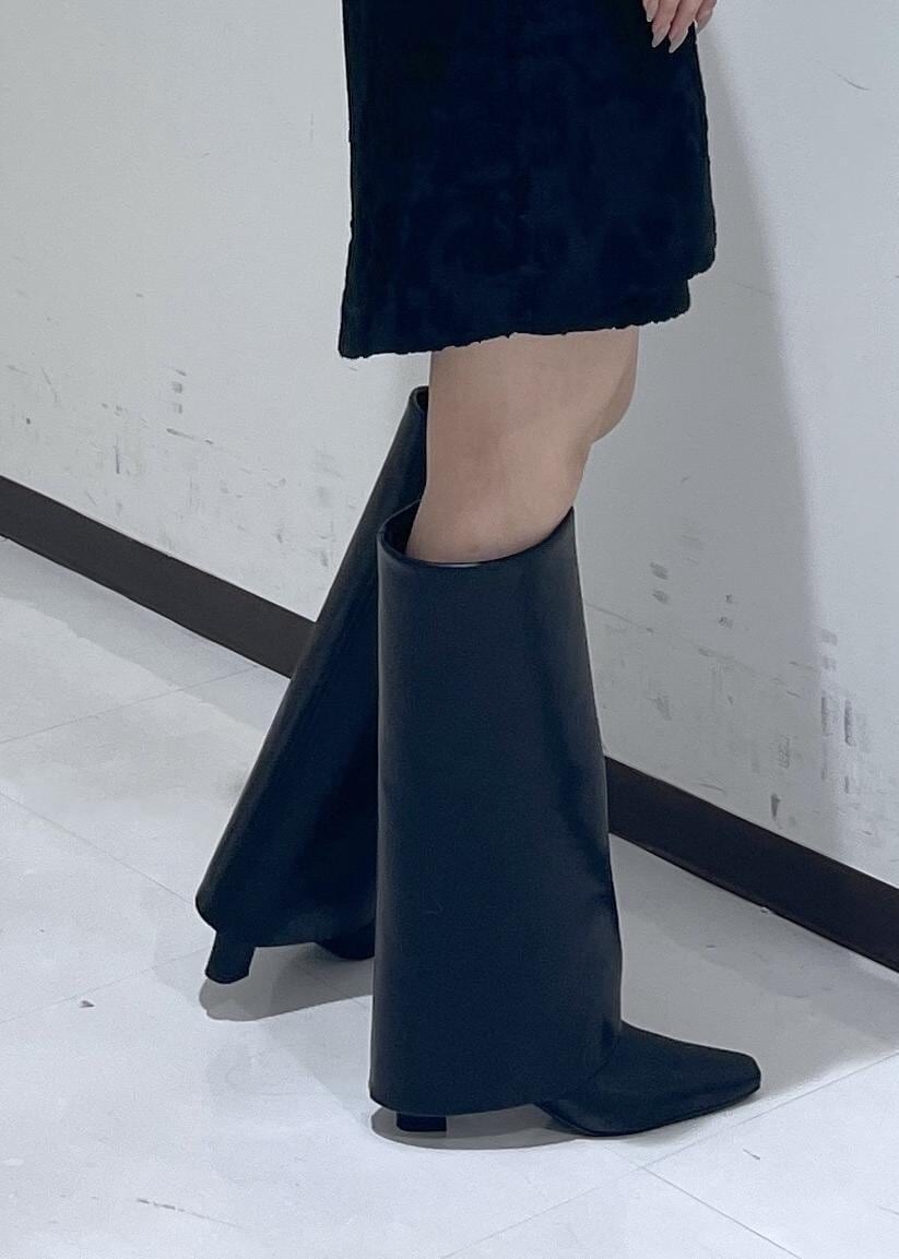 ブラック系のスカート、ブラック系のブーツ、ホワイト系のTシャツ/カットソーを着用したレディースの秋コーディネートの9枚目の写真