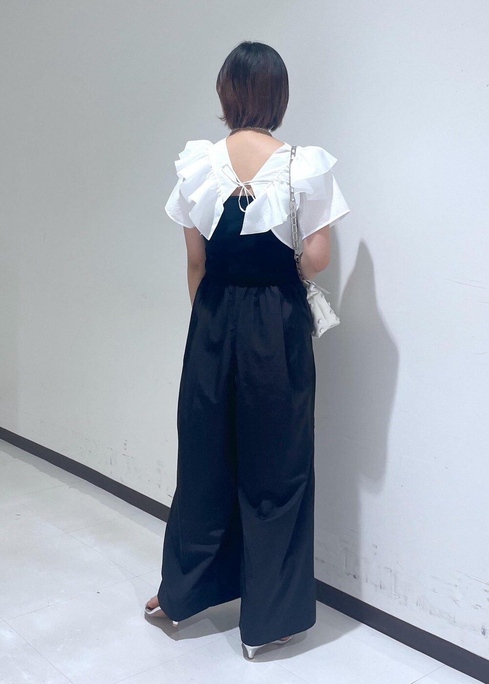 シルバー系のサンダル、ホワイト系のシャツ/ブラウス、ブラック系のつなぎ/オールインワンを着用したレディースの夏コーディネートの4枚目の写真