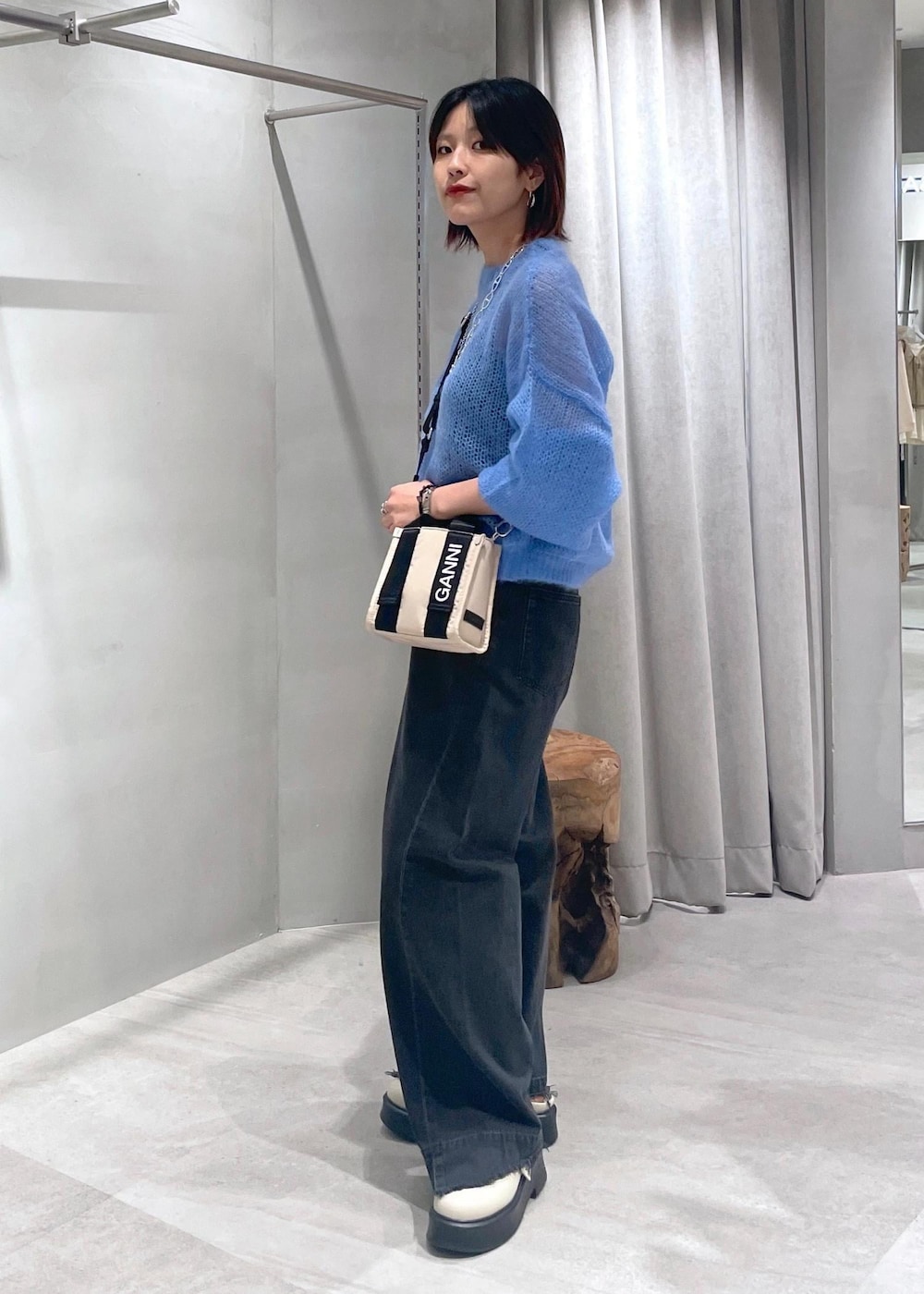 ベージュ系のトートバッグ、ベージュ系のサンダル、ブルー系のニット/セーターを着用したレディースの夏コーディネートの2枚目の写真