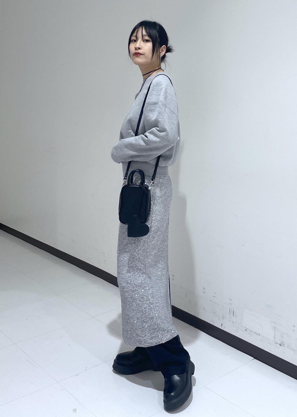 ブラック系のサンダル、ブラック系のスラックス、グレー系のスカートを着用したレディースの冬コーディネートの2枚目の写真