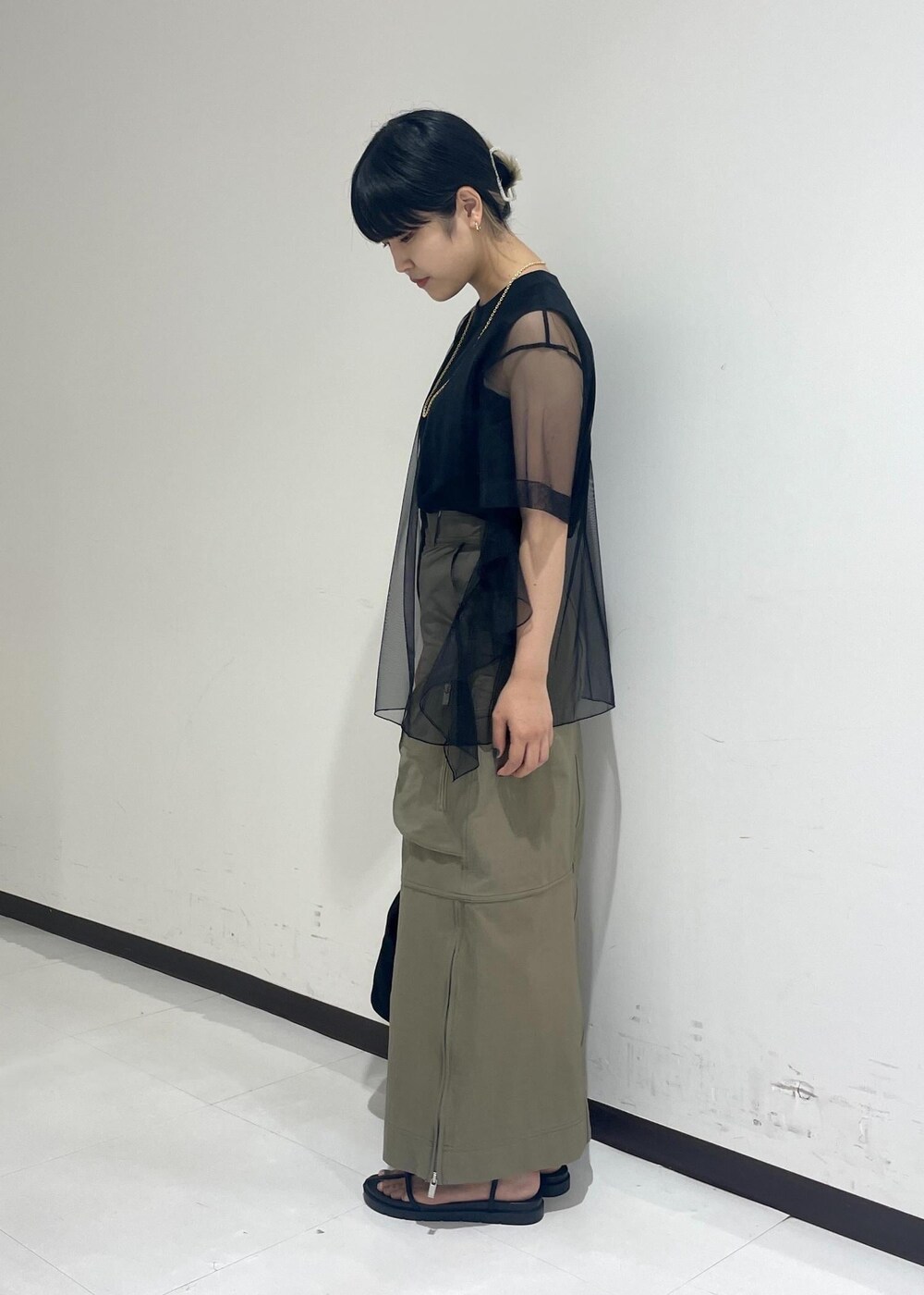 ブラック系のサンダル、ブラック系のショルダーバッグ、ベージュ系のスカートを着用したレディースの夏コーディネートの4枚目の写真