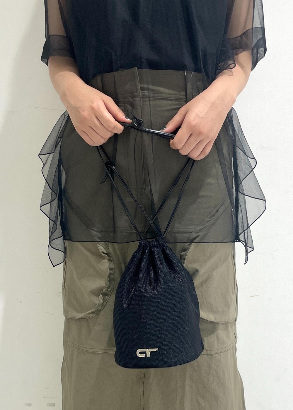 ブラック系のサンダル、ブラック系のショルダーバッグ、ベージュ系のスカートを着用したレディースの夏コーディネートの10枚目の写真