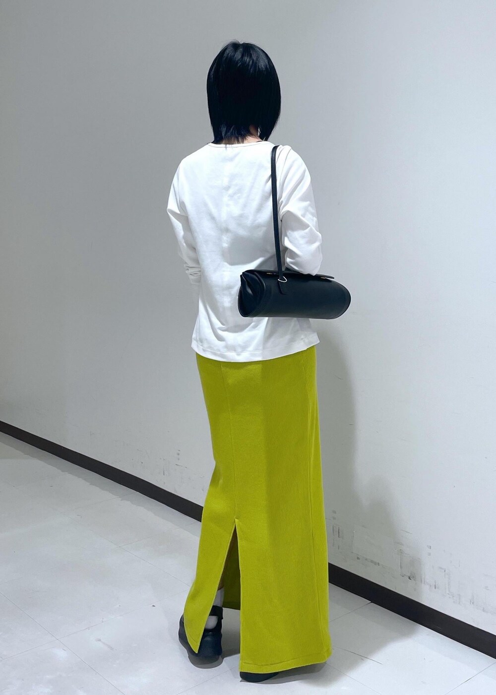 ブラック系のサンダル、ホワイト系のTシャツ/カットソー、ブラック系のショルダーバッグを着用したレディースの秋コーディネートの4枚目の写真