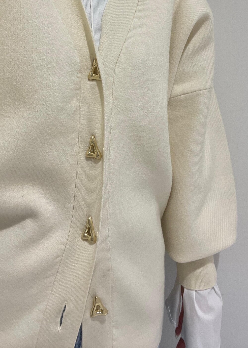 ホワイト系のカーディガン/ボレロ、ブルー系のデニムパンツ、ホワイト系のTシャツ/カットソーを着用したレディースの冬コーディネートの6枚目の写真