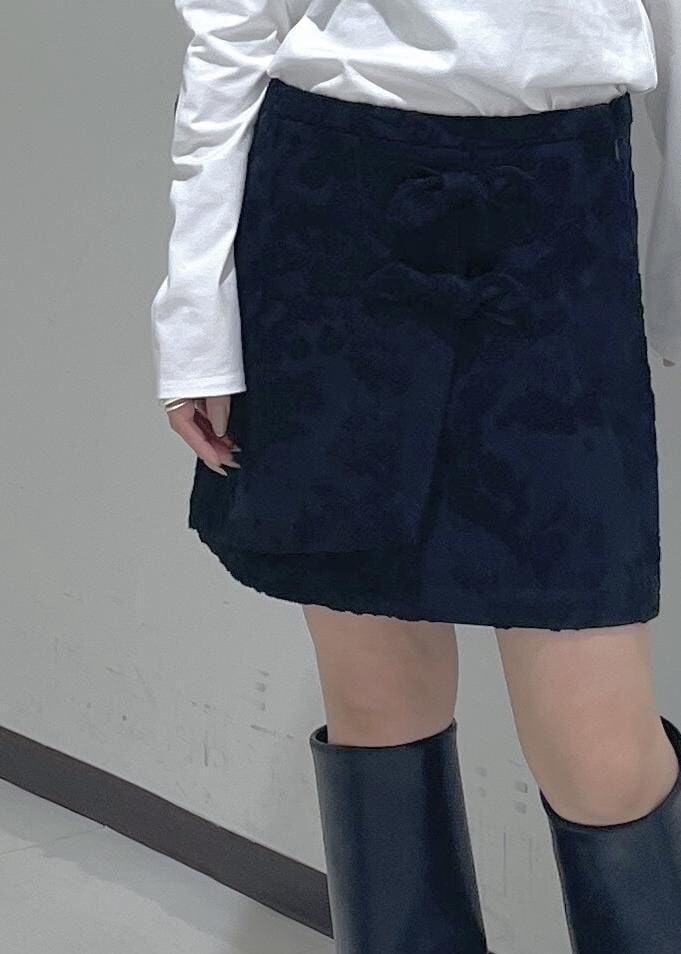 ブラック系のスカート、ブラック系のブーツ、ホワイト系のTシャツ/カットソーを着用したレディースの秋コーディネートの8枚目の写真