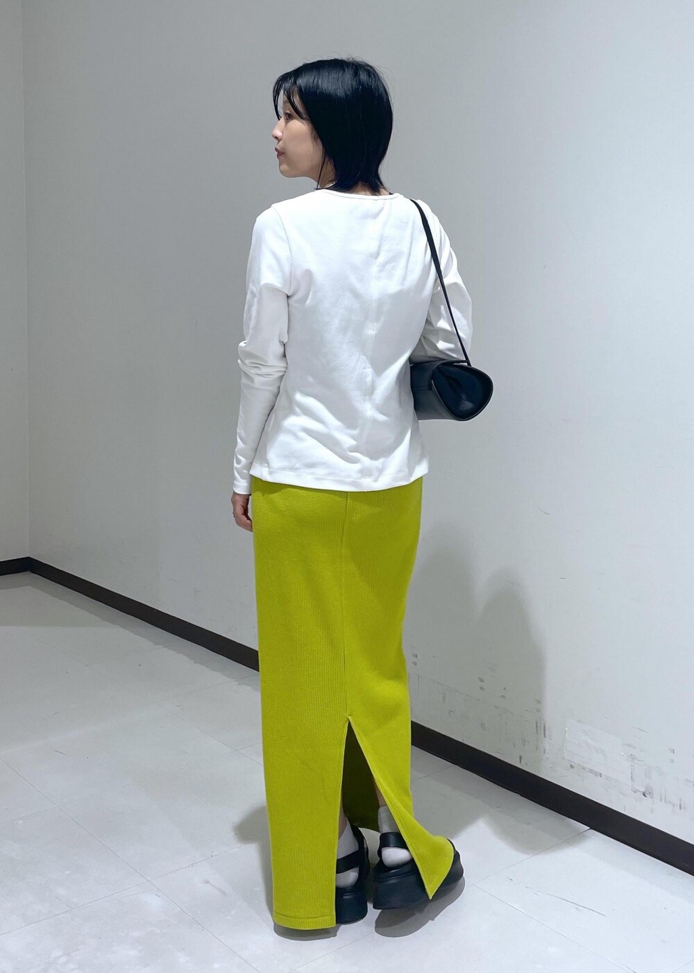 ブラック系のサンダル、ホワイト系のTシャツ/カットソー、ブラック系のショルダーバッグを着用したレディースの秋コーディネートの3枚目の写真