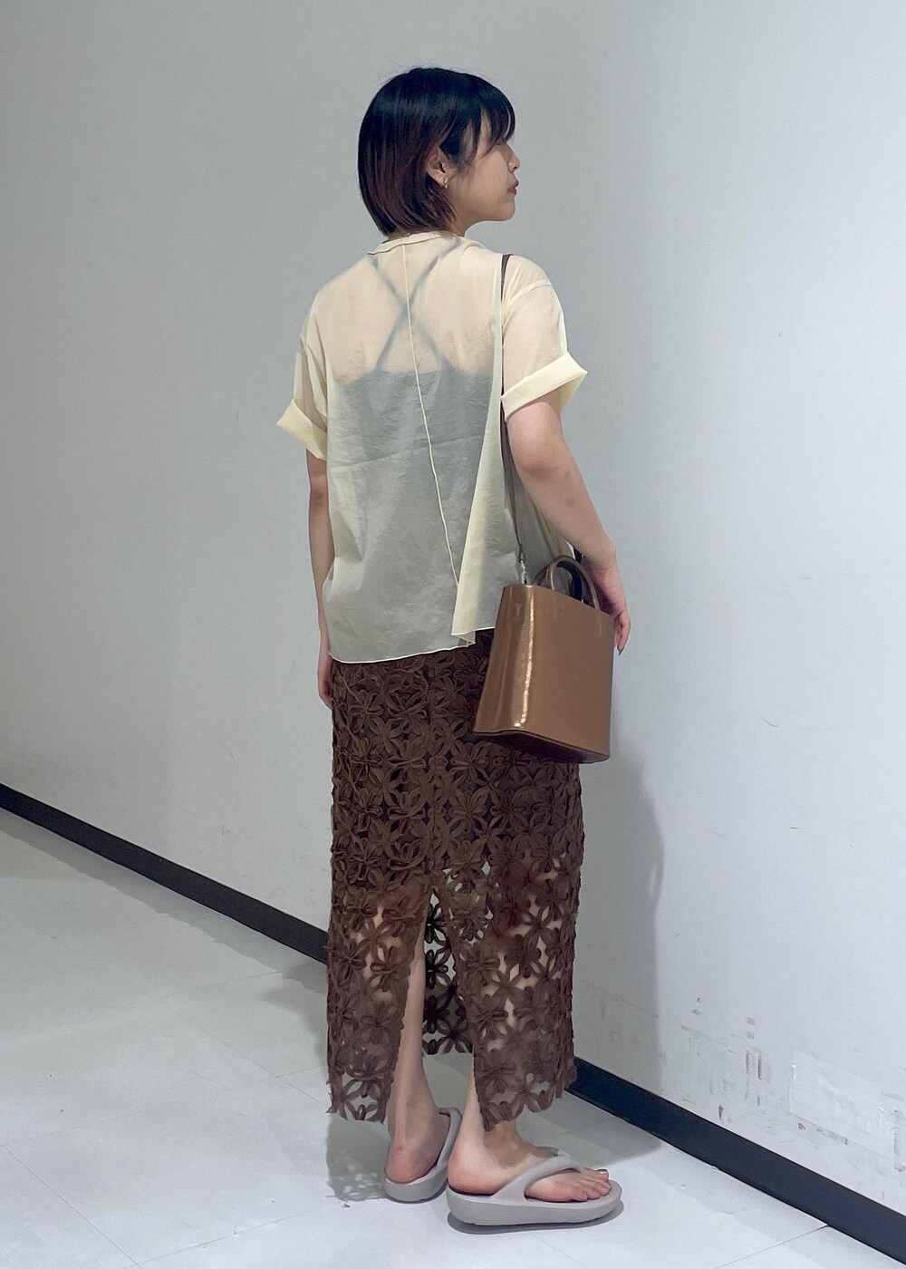 グレー系のサンダル、ベージュ系のTシャツ/カットソー、その他のハンドバッグを着用したレディースの夏コーディネートの3枚目の写真