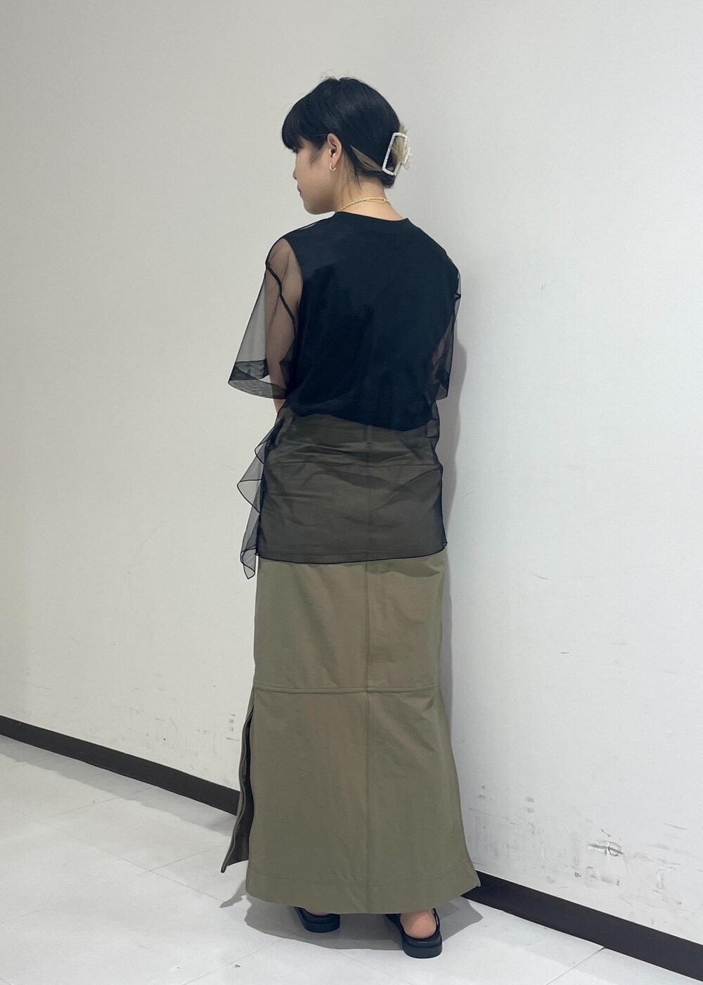 ブラック系のサンダル、ブラック系のショルダーバッグ、ベージュ系のスカートを着用したレディースの夏コーディネートの6枚目の写真