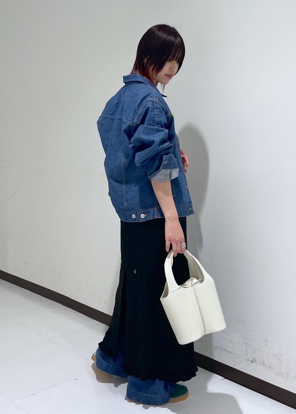 グリーン系のスニーカー、ブラック系のワンピース、ブルー系のブルゾンを着用したレディースの春コーディネートの4枚目の写真