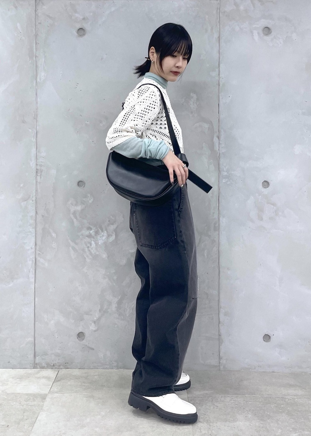 ホワイト系のローファー、グリーン系のニット/セーター、ブラック系のデニムパンツを着用したレディースの冬コーディネートの6枚目の写真