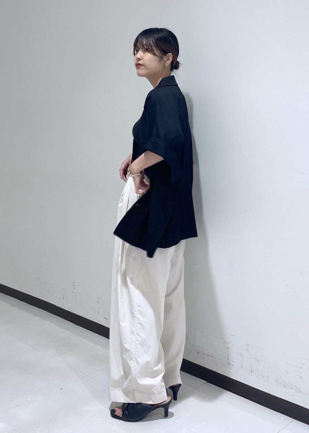 ブラック系のサンダル、ホワイト系のショルダーバッグ、ブラック系のテーラードジャケットを着用したレディースの春コーディネートの2枚目の写真