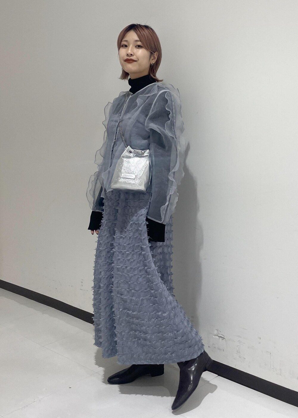 ブラウン系のブーツ、ブラック系のニット/セーター、ブラック系のネックレスを着用したレディースの冬コーディネートの2枚目の写真