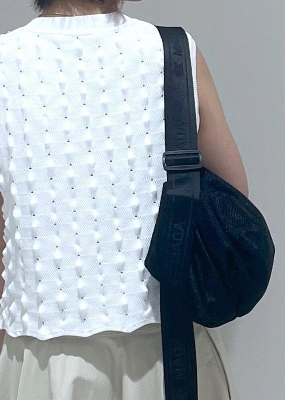 ベージュ系のスカート、ホワイト系のニット/セーター、ブルー系のキャップを着用したレディースの夏コーディネートの7枚目の写真