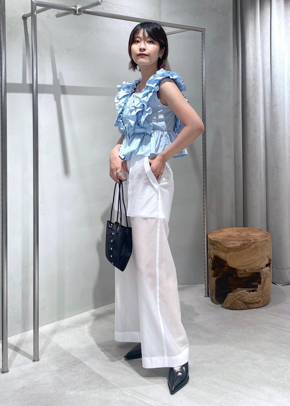 ブラック系のパンプス、ホワイト系のその他パンツ、ブルー系のシャツ/ブラウスを着用したレディースの夏コーディネートの2枚目の写真
