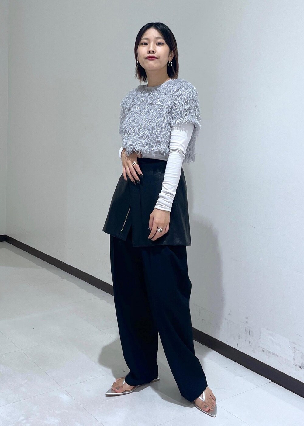 シルバー系のサンダル、グレー系のTシャツ/カットソー、ブラック系のスカートを着用したレディースの夏コーディネートの2枚目の写真