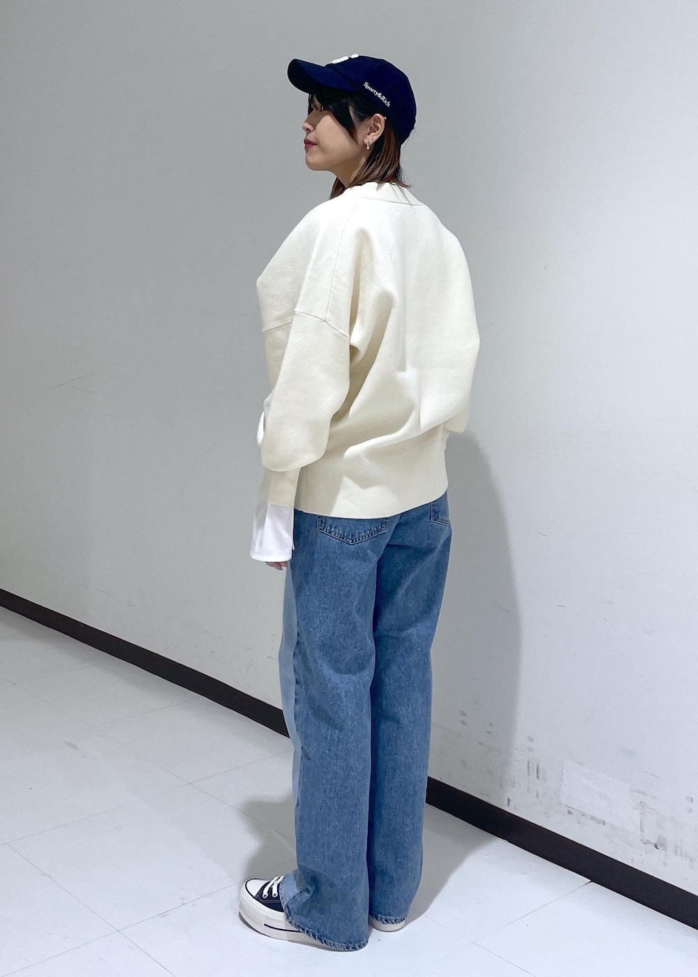 ホワイト系のカーディガン/ボレロ、ブルー系のデニムパンツ、ホワイト系のTシャツ/カットソーを着用したレディースの冬コーディネートの3枚目の写真