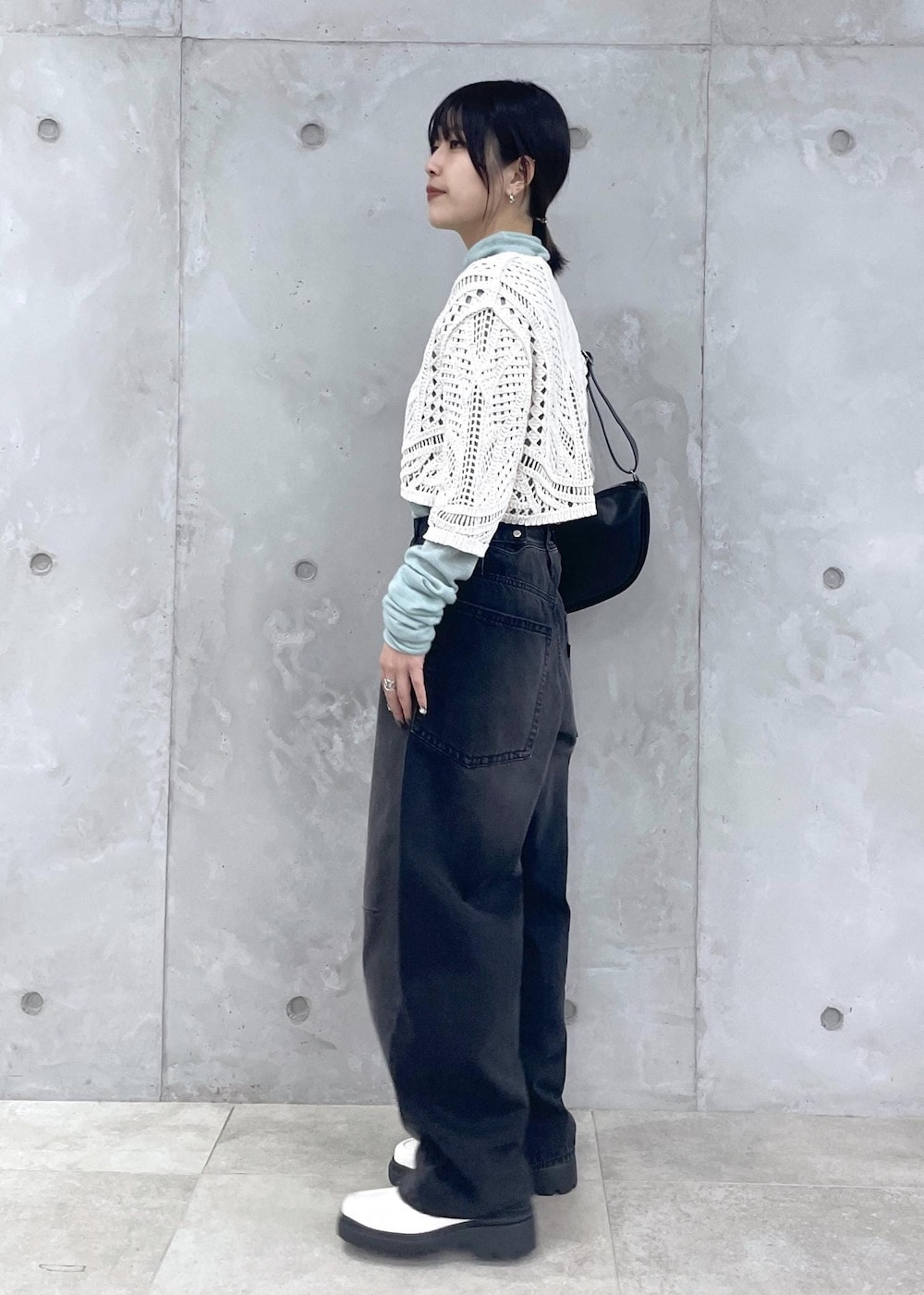 ホワイト系のローファー、グリーン系のニット/セーター、ブラック系のデニムパンツを着用したレディースの冬コーディネートの2枚目の写真