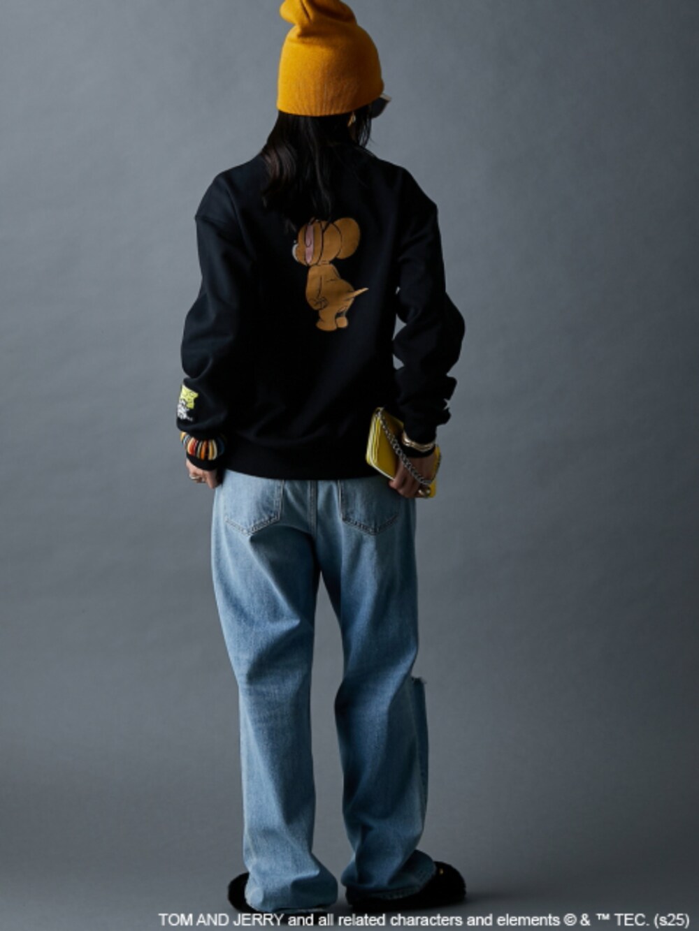 ブラック系のスウェット、ブルー系のデニムパンツを着用したレディースの秋コーディネートの2枚目の写真