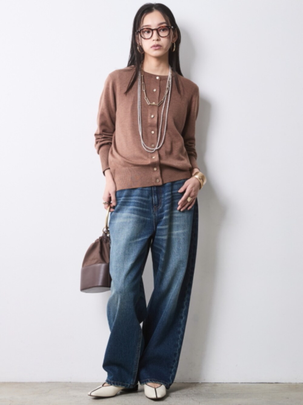 ブラウン系のカーディガン/ボレロ、ブルー系のデニムパンツ、ブラック系のベルトを着用したレディースの冬コーディネートの2枚目の写真