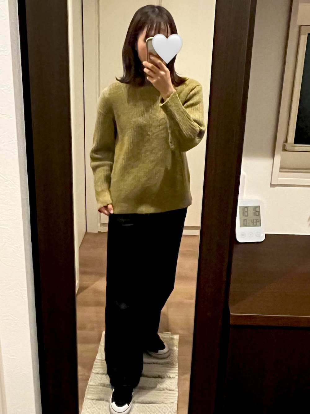 ブラック系のデニムパンツ、グリーン系のニット/セーター、ブラック系のダウンジャケット/コートを着用したレディースの冬コーディネートの3枚目の写真