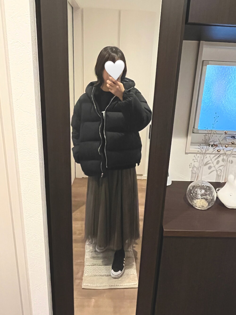 グリーン系のニット/セーター、ベージュ系のスカートを着用したレディースの冬コーディネートの5枚目の写真