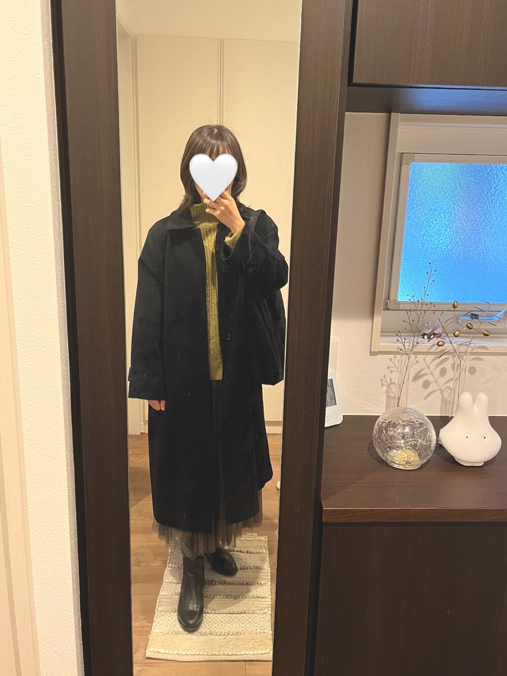 グリーン系のニット/セーター、ベージュ系のスカートを着用したレディースの冬コーディネートの2枚目の写真