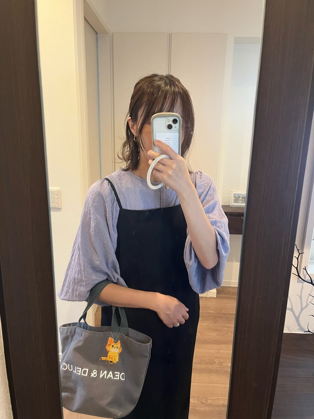 ブルー系のシャツ/ブラウス、ブラック系のワンピース、ホワイト系のスニーカーを着用したレディースの秋コーディネートの3枚目の写真
