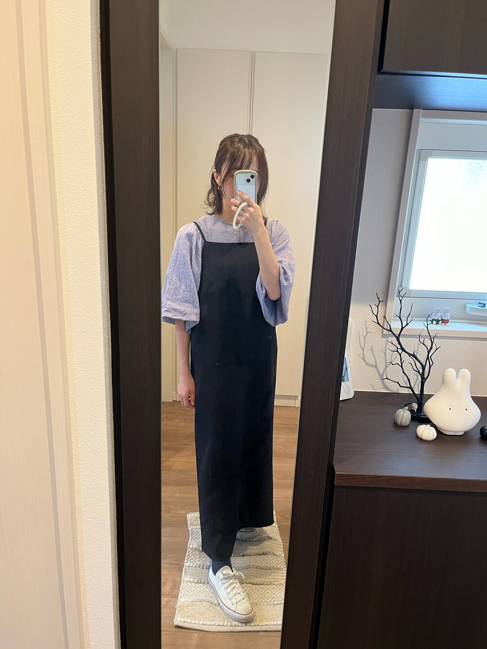 ブルー系のシャツ/ブラウス、ブラック系のワンピース、ホワイト系のスニーカーを着用したレディースの秋コーディネートの2枚目の写真