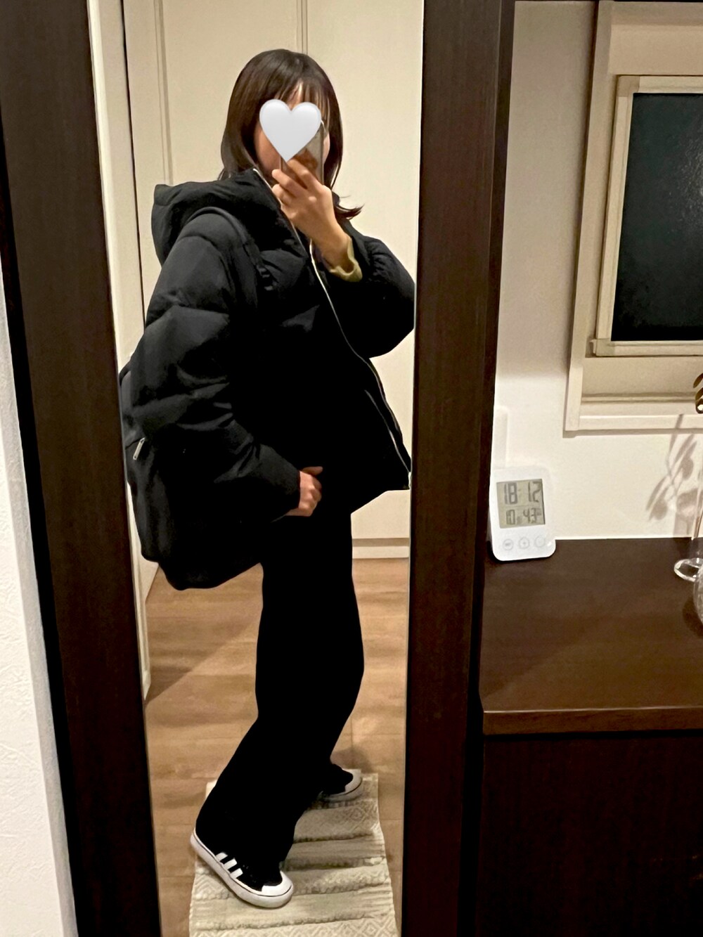 ブラック系のデニムパンツ、グリーン系のニット/セーター、ブラック系のダウンジャケット/コートを着用したレディースの冬コーディネートの2枚目の写真