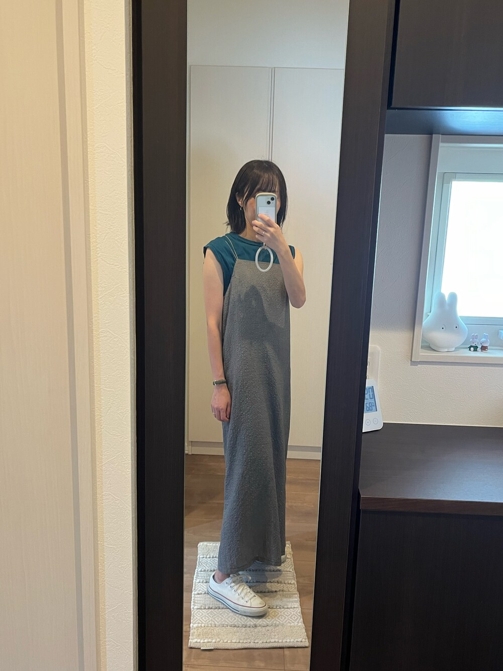 ブラック系のワンピース、ホワイト系のスニーカー、ブルー系のトップスを着用したレディースの秋コーディネートの2枚目の写真