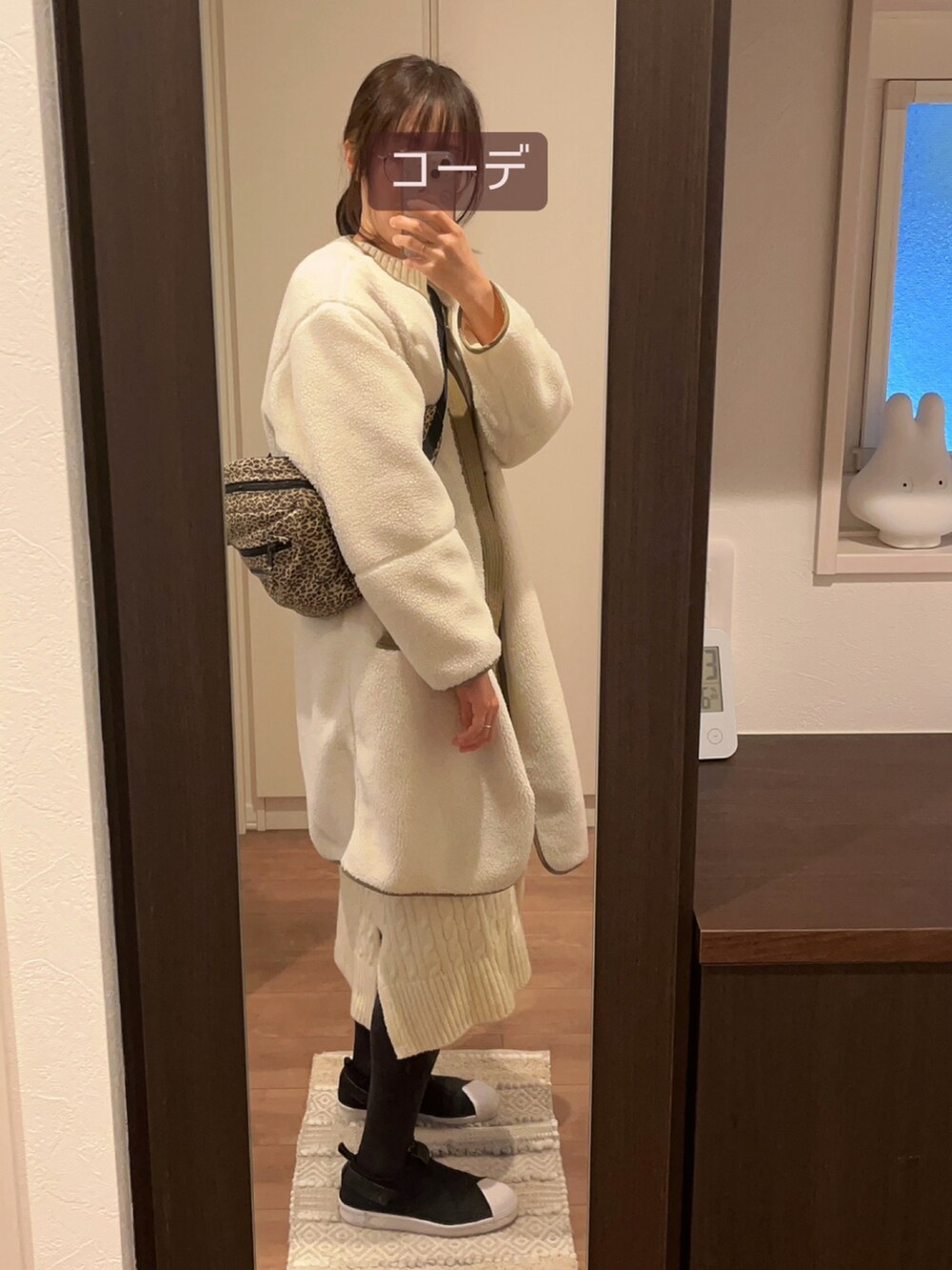 ホワイト系のノーカラージャケット、ブラック系のスニーカー、ベージュ系のショルダーバッグを着用したレディースの冬コーディネートの2枚目の写真