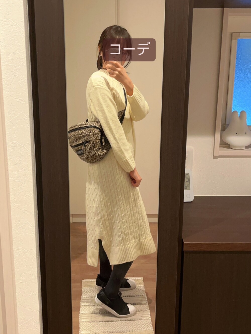 ホワイト系のノーカラージャケット、ブラック系のスニーカー、ベージュ系のショルダーバッグを着用したレディースの冬コーディネートの4枚目の写真