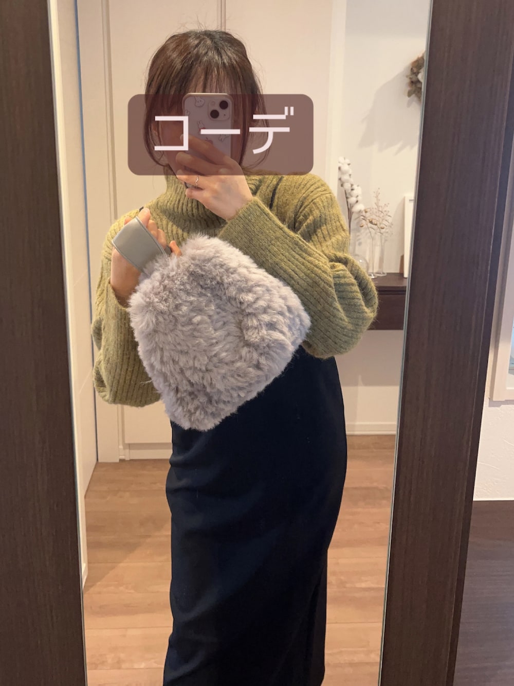 ブラック系のワンピース、グリーン系のニット/セーター、グレー系のハンドバッグを着用したレディースの冬コーディネートの2枚目の写真