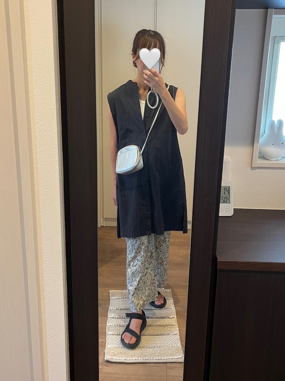 ブラック系のトップス、シルバー系のショルダーバッグ、ブラック系のサンダルを着用したレディースの秋コーディネートの2枚目の写真