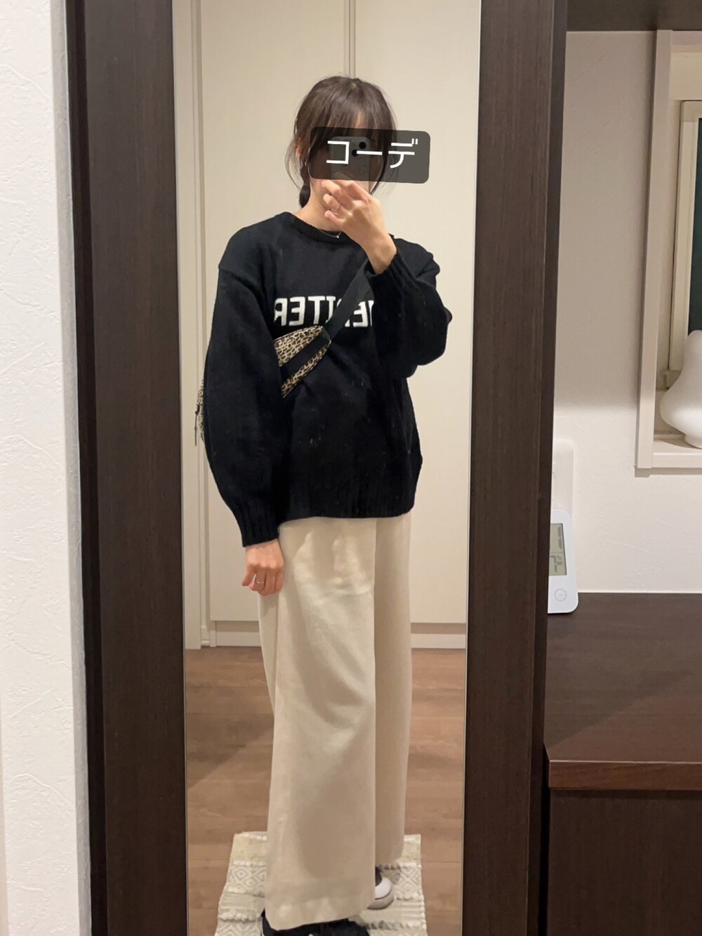 ブラック系のシューズ、ホワイト系のパンツ、ベージュ系のショルダーバッグを着用したレディースの冬コーディネートの3枚目の写真