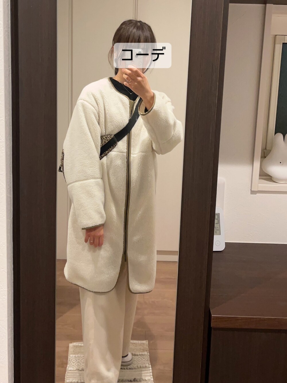 ブラック系のシューズ、ホワイト系のパンツ、ベージュ系のショルダーバッグを着用したレディースの冬コーディネートの2枚目の写真