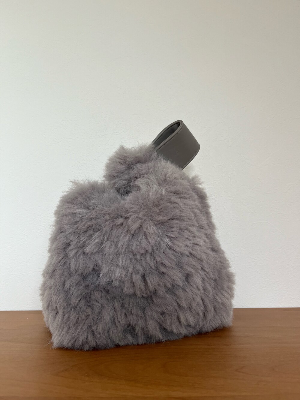 ブラック系のワンピース、グリーン系のニット/セーター、グレー系のハンドバッグを着用したレディースの冬コーディネートの3枚目の写真