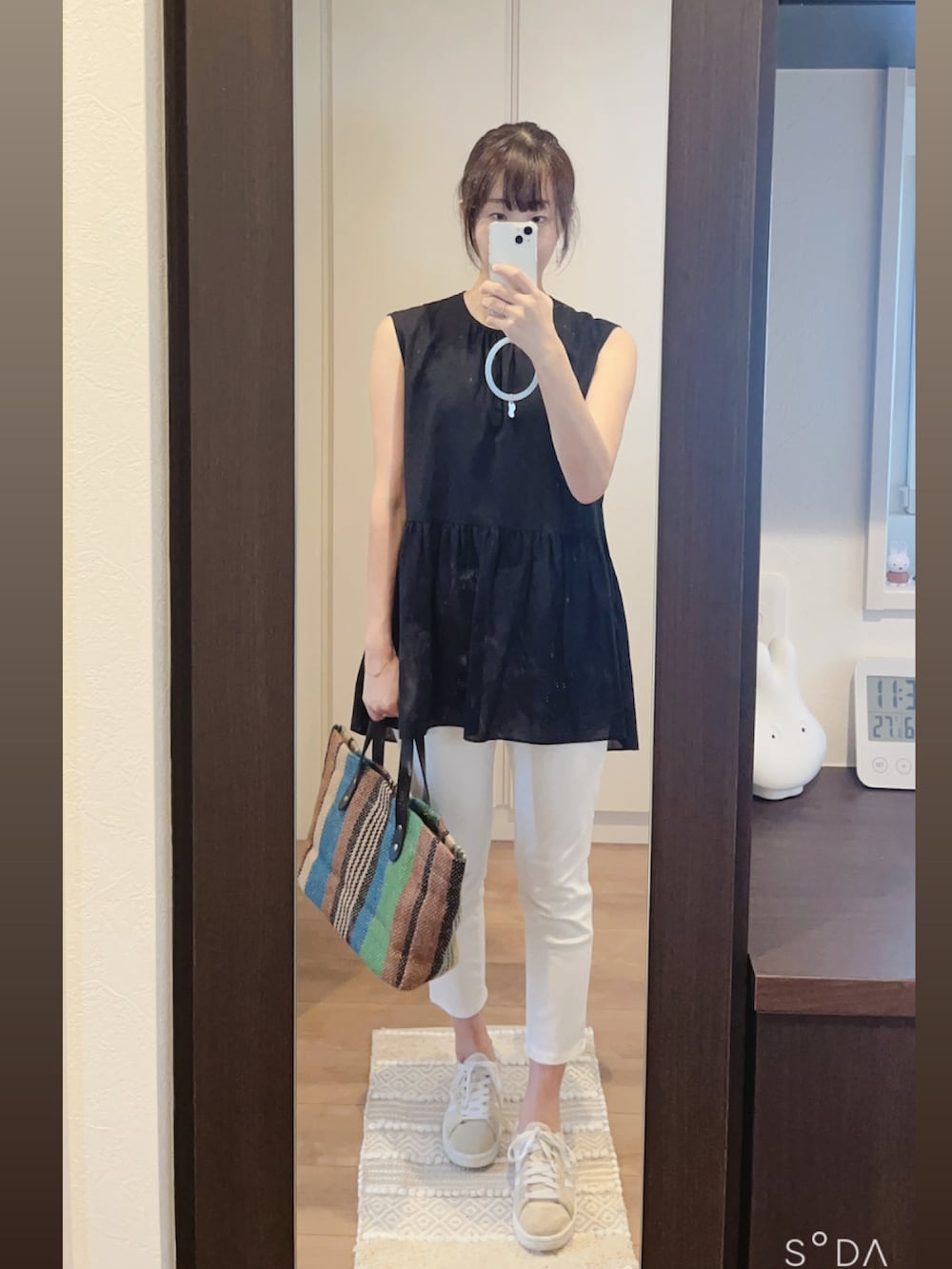 ホワイト系のパンツ、ブラック系のシャツ/ブラウス、グリーン系のトートバッグを着用したレディースの春コーディネートの2枚目の写真