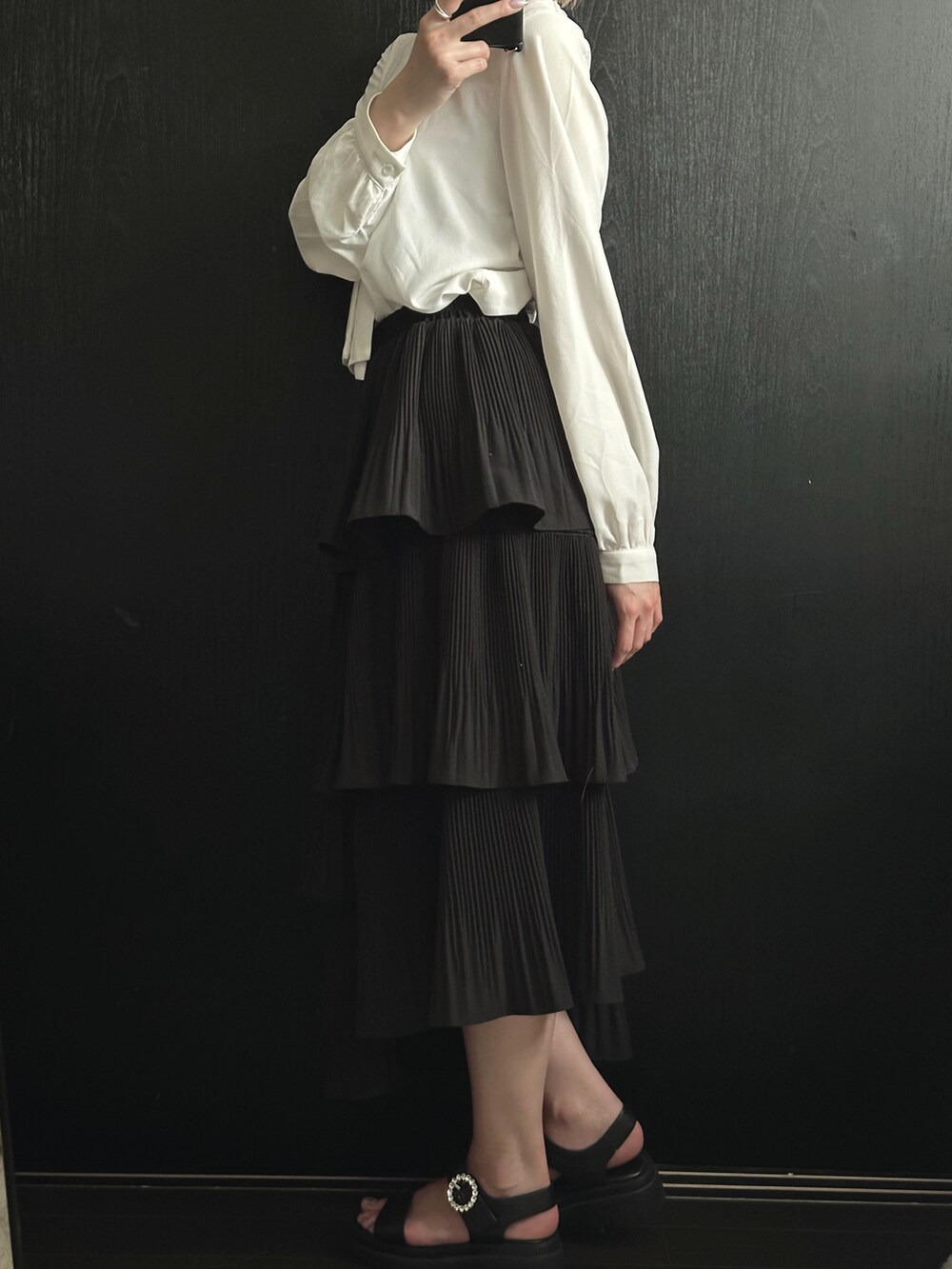 ホワイト系のシャツ/ブラウス、ブラック系のスカート、ブラック系のサンダルを着用したレディースの夏コーディネートの3枚目の写真