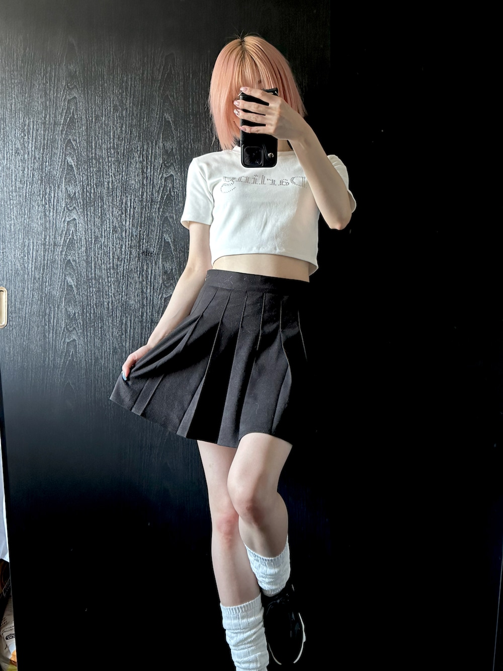 ホワイト系のTシャツ/カットソー、ブラック系のスカート、ブラック系のスニーカーを着用したレディースの夏コーディネートの2枚目の写真