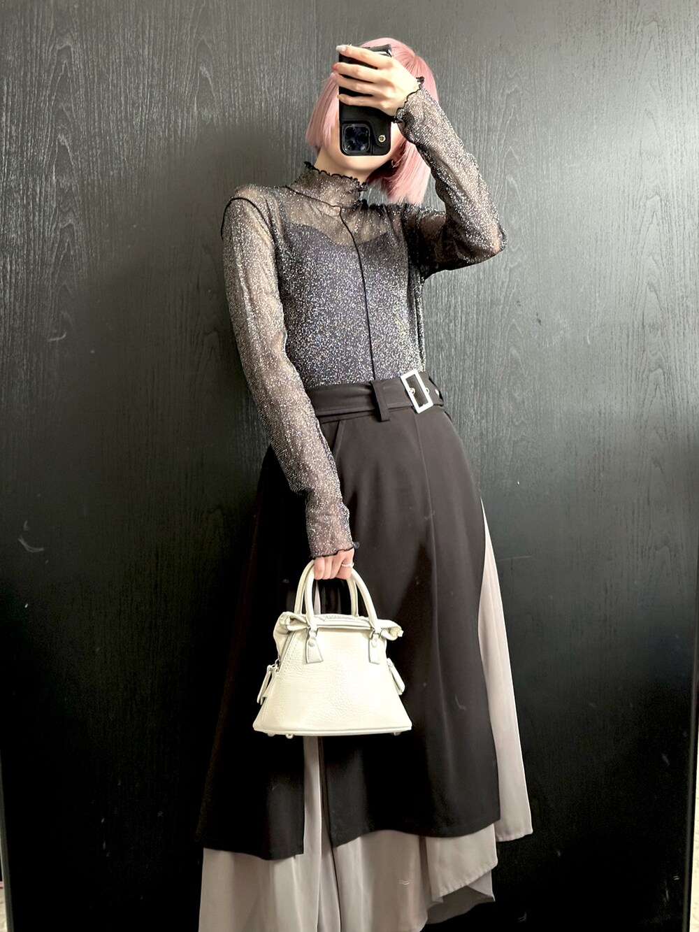 ブラック系のトップス、ブラック系のスカート、ホワイト系のハンドバッグを着用したレディースの夏コーディネートの3枚目の写真