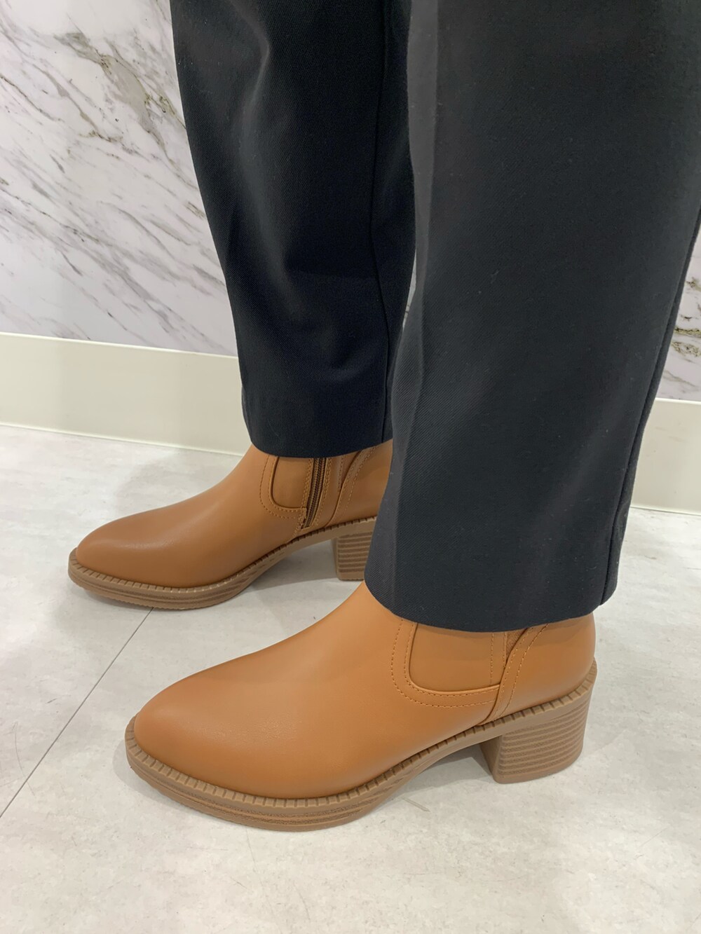 ブラウン系のブーツを着用したレディースの冬コーディネートの2枚目の写真