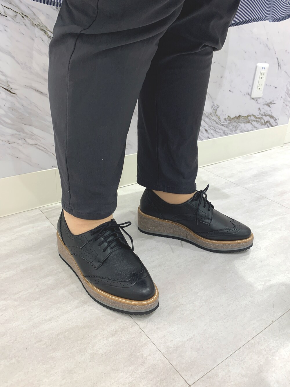 ブラック系のパンプスを着用したレディースの春コーディネートの2枚目の写真